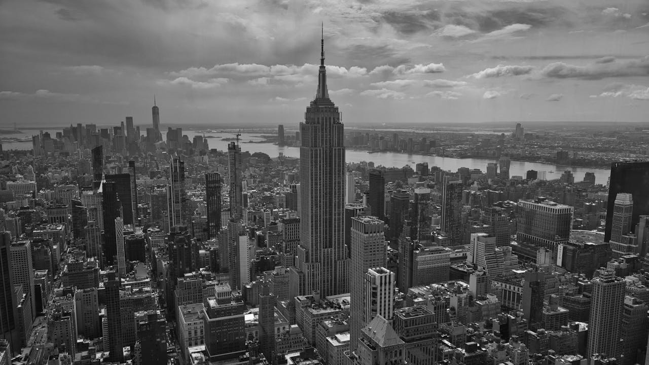 Monochrome aerial view of New York City skyline featuring the iconic Empire State Building.